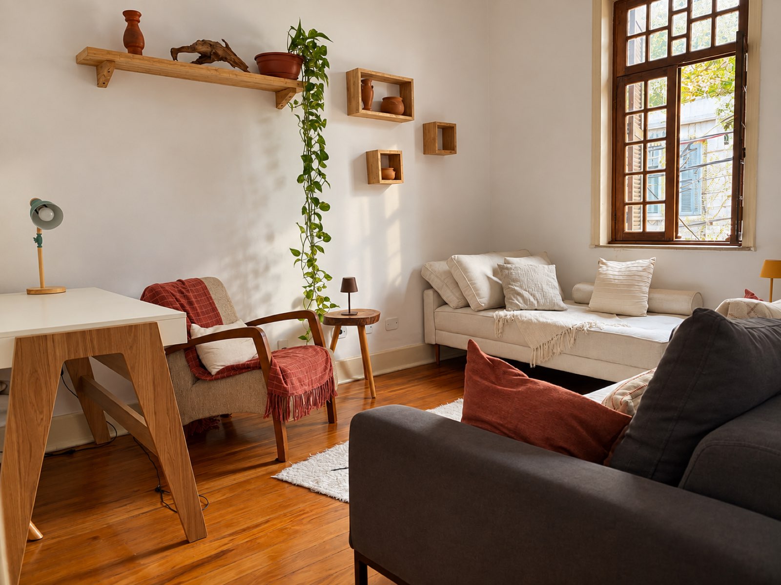 Sala de atendimento da clínica, com poltrona, sofá e janela de madeira